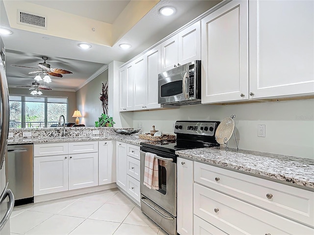 kitchen with white cabinetry, visible vents, stainless steel appliances, and crown molding