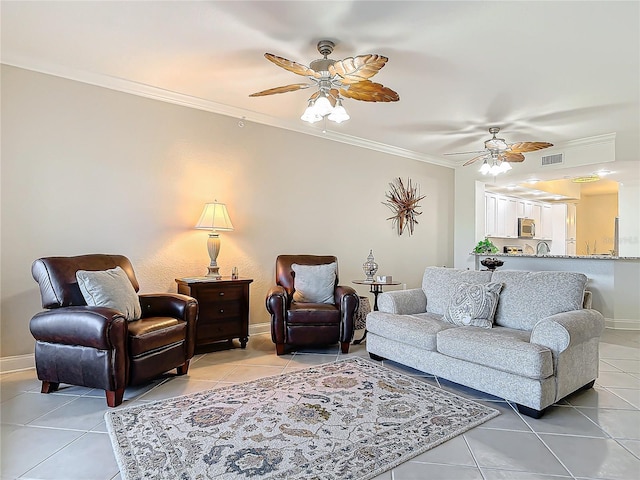 living room featuring light tile patterned floors, visible vents, a ceiling fan, and ornamental molding