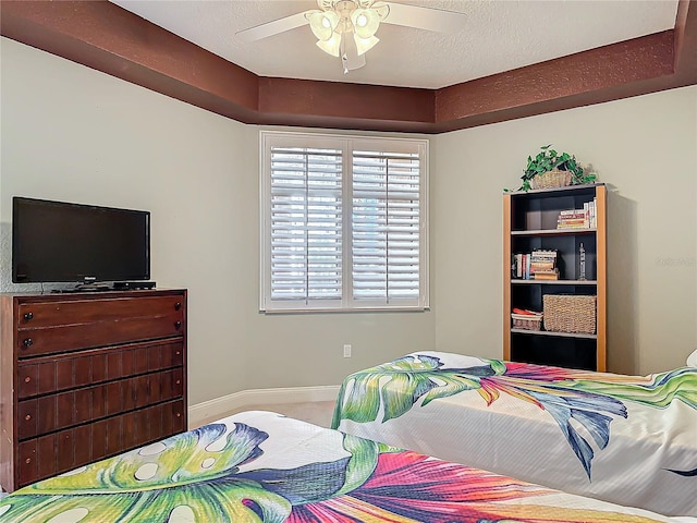 bedroom with a ceiling fan, a textured ceiling, and baseboards