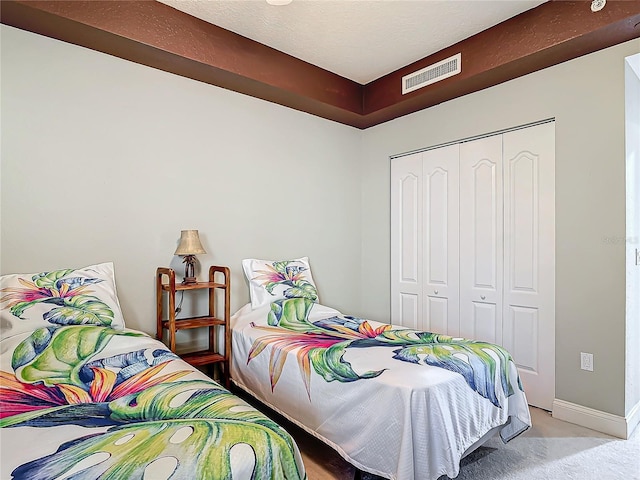 bedroom featuring carpet, a closet, visible vents, and baseboards