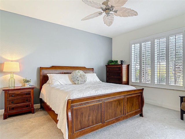 bedroom featuring light carpet, ceiling fan, and baseboards