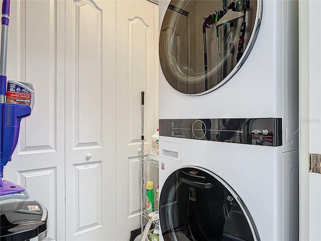 washroom with stacked washing maching and dryer and laundry area