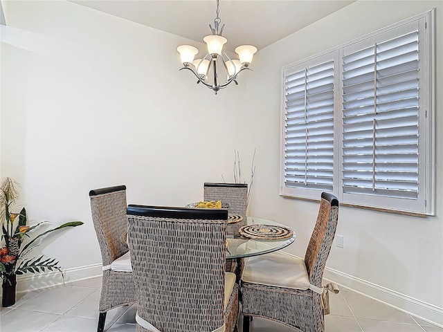 tiled dining area with a notable chandelier and baseboards