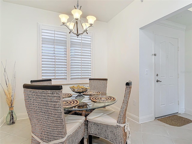 tiled dining room featuring baseboards and an inviting chandelier