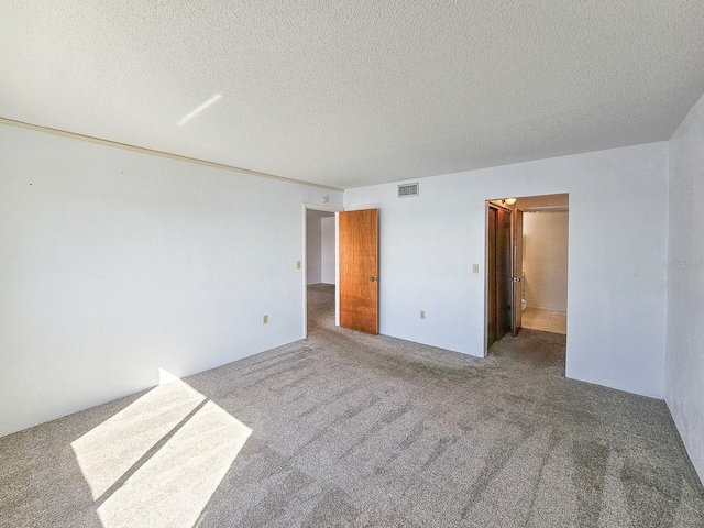 spare room featuring carpet floors and a textured ceiling