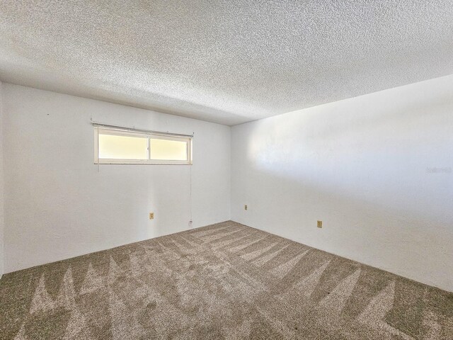 empty room featuring carpet floors and a textured ceiling