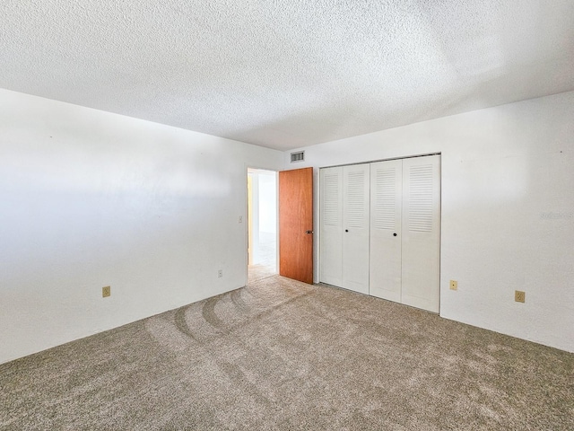 unfurnished bedroom with a closet, a textured ceiling, and carpet flooring