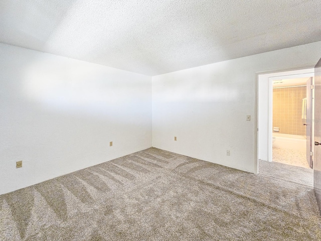 spare room featuring a textured ceiling and carpet