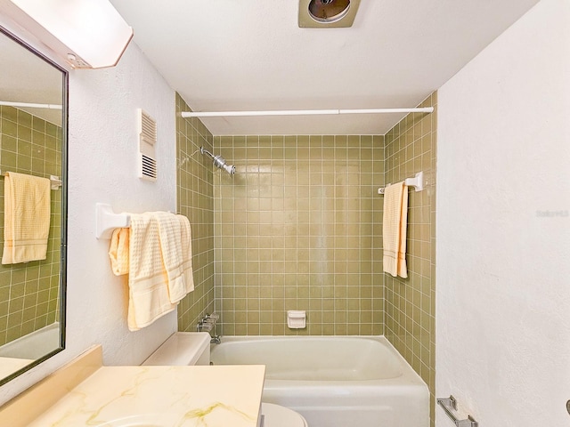 full bathroom featuring tiled shower / bath combo, vanity, and toilet