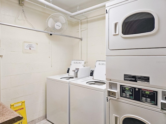 washroom with stacked washer and clothes dryer and washer and clothes dryer