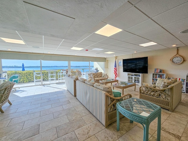 living room with a drop ceiling and a water view