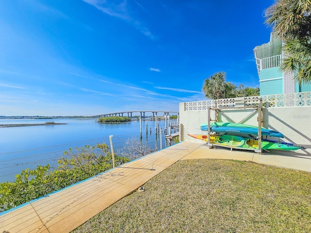 dock area with a water view and a lawn