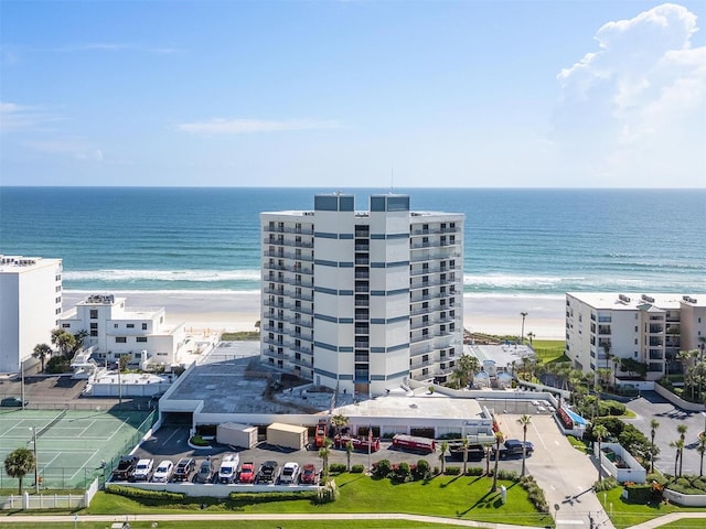 birds eye view of property with a water view and a beach view