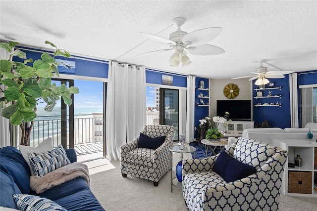 living room with ceiling fan, carpet flooring, and a textured ceiling