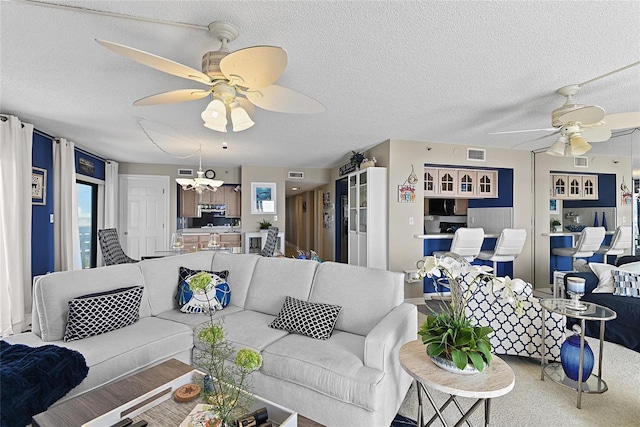 carpeted living room featuring ceiling fan and a textured ceiling