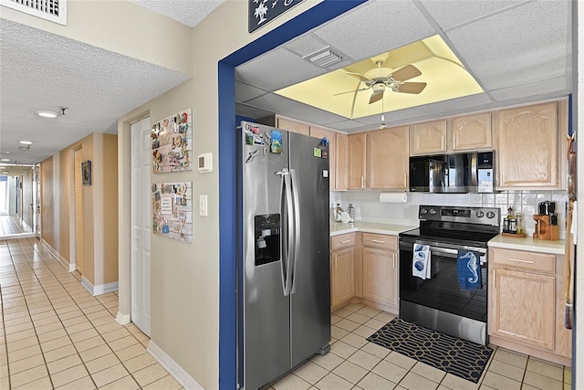 kitchen featuring light tile patterned floors, light brown cabinets, ceiling fan, stainless steel appliances, and decorative backsplash