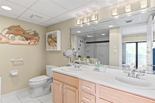 bathroom with tile patterned floors, toilet, a paneled ceiling, vanity, and a shower with door