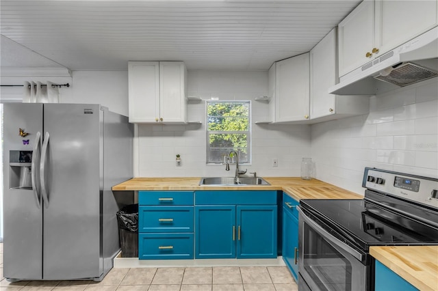 kitchen with stainless steel appliances, butcher block counters, white cabinets, and blue cabinetry