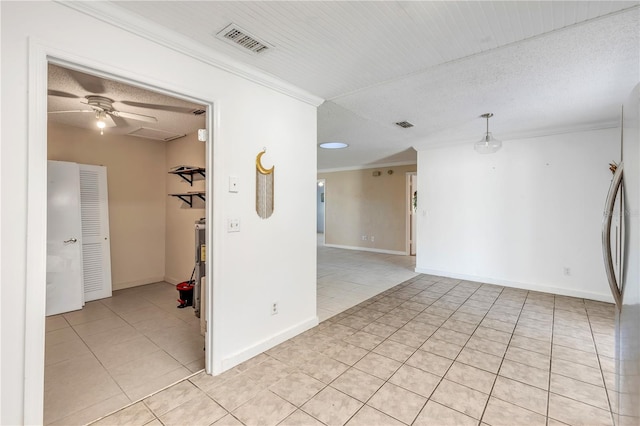 spare room with light tile patterned flooring, ceiling fan, crown molding, and a textured ceiling