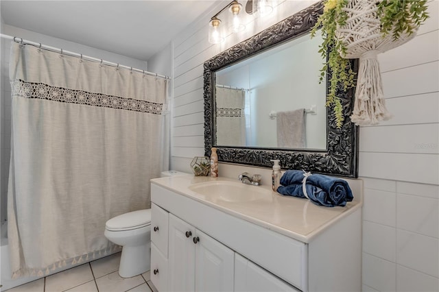 bathroom featuring wooden walls, vanity, toilet, and tile patterned flooring