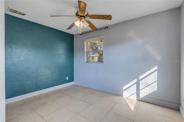 tiled empty room with a textured ceiling and ceiling fan