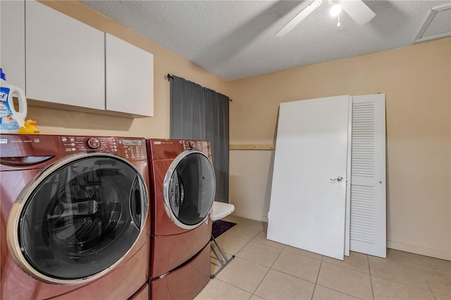 washroom featuring light tile patterned flooring, cabinets, washing machine and clothes dryer, ceiling fan, and a textured ceiling