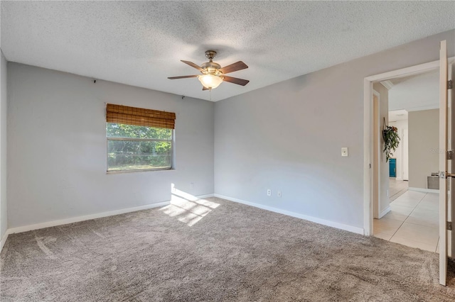 carpeted spare room with a textured ceiling and ceiling fan