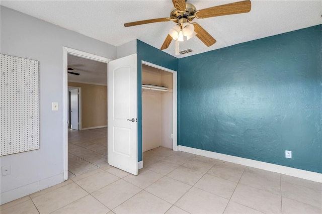 unfurnished bedroom with light tile patterned floors, a closet, and ceiling fan