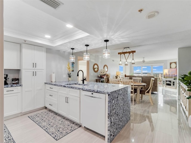 kitchen featuring sink, light stone countertops, white cabinets, and dishwasher