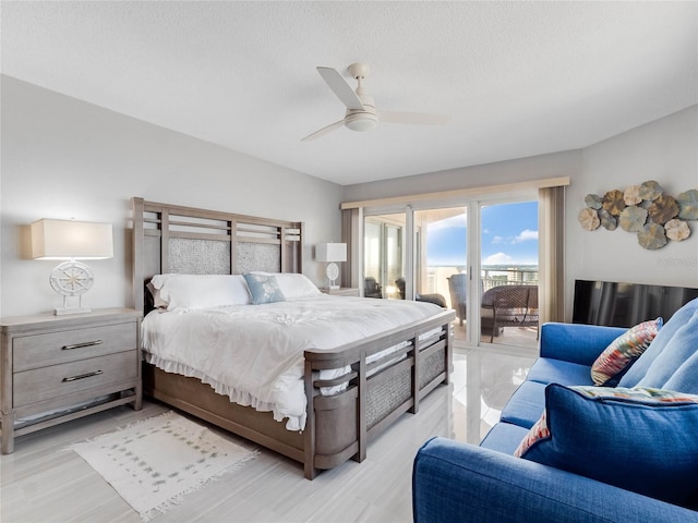 bedroom with a textured ceiling, access to outside, and ceiling fan