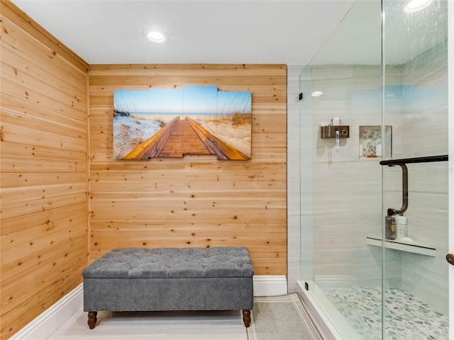 bathroom with wooden walls and a shower with shower door