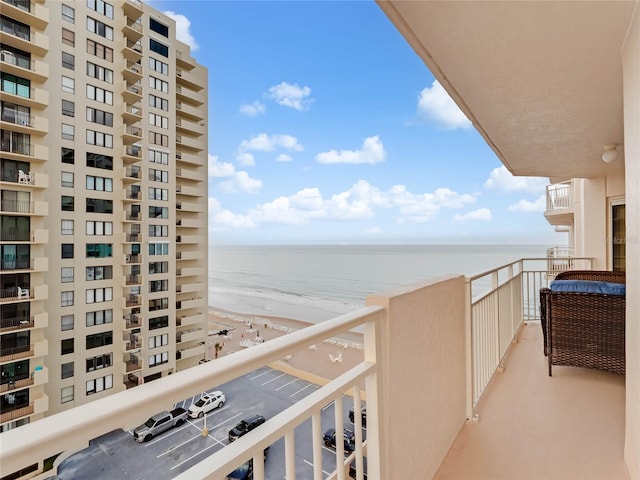 balcony featuring a view of the beach and a water view