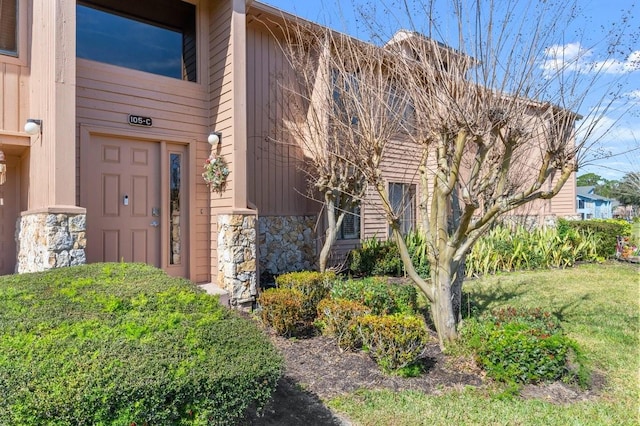 view of exterior entry featuring a yard