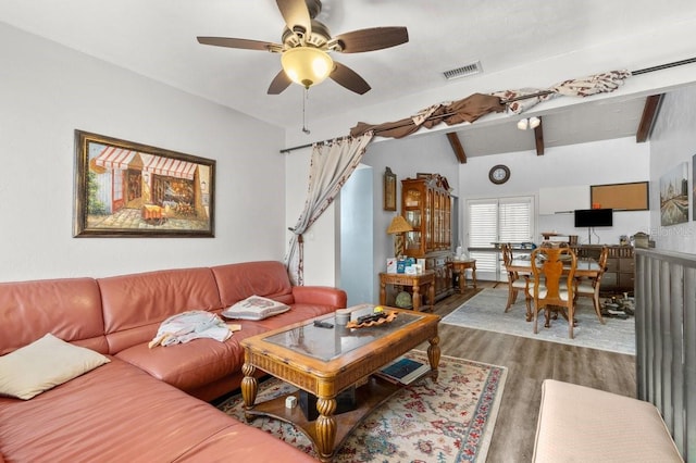 living room with ceiling fan, wood-type flooring, and vaulted ceiling with beams