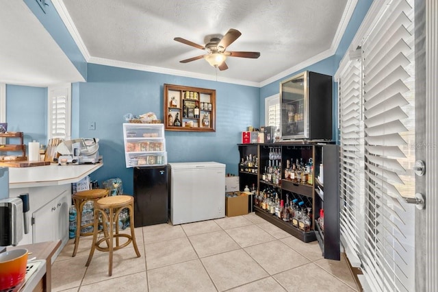 laundry area featuring ornamental molding, plenty of natural light, light tile patterned floors, and ceiling fan