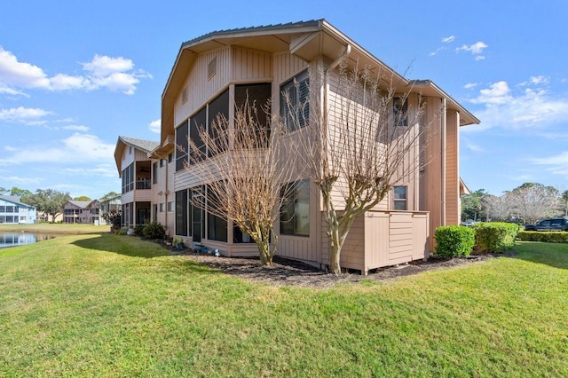 back of house with a yard and a water view