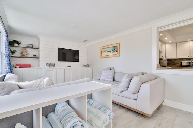 living room with crown molding and light wood-type flooring