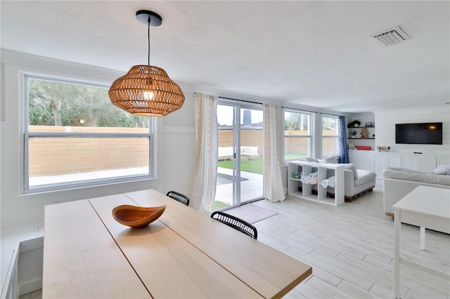 dining room featuring a healthy amount of sunlight and light hardwood / wood-style flooring