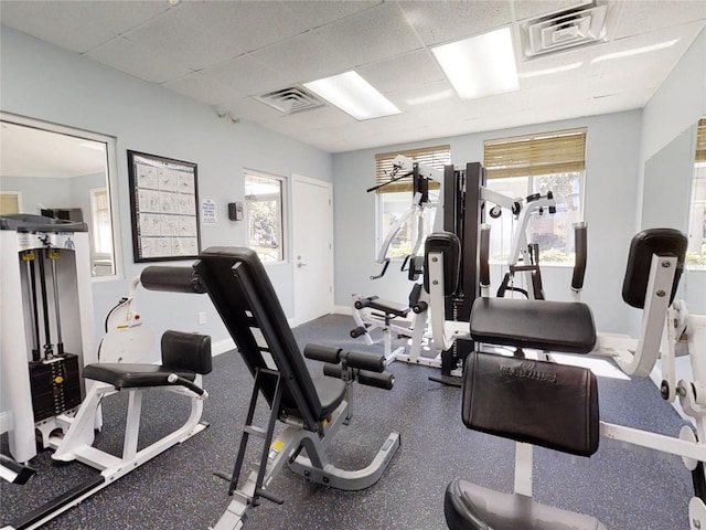 workout area with plenty of natural light and a drop ceiling