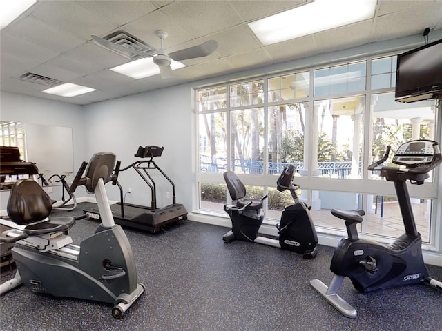 gym featuring a drop ceiling and ceiling fan