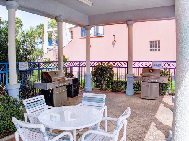 5300 S Atlantic Ave Unit 3-504, New Smyrna Beach, FL 32169 - view of patio featuring ceiling fan, fence, outdoor dining area, and a grill