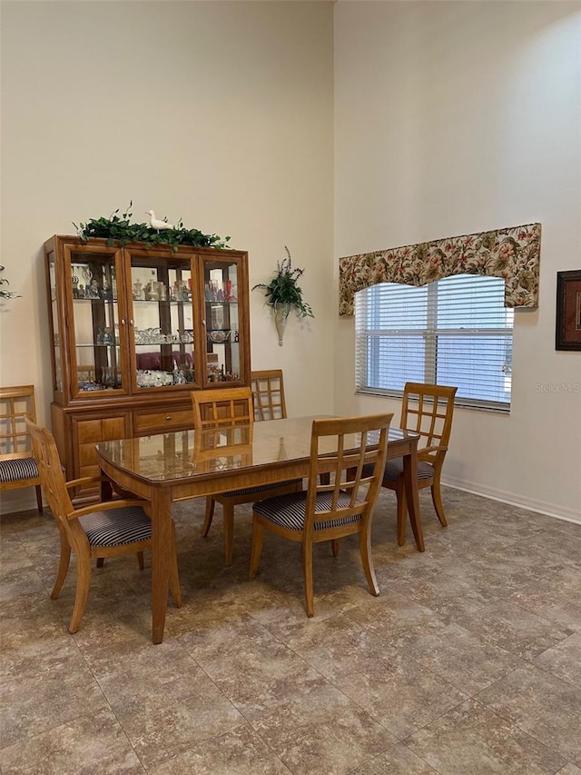 dining room with a towering ceiling