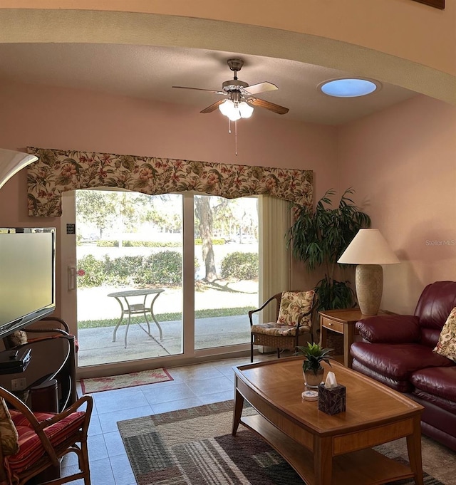 tiled living room with a water view and ceiling fan