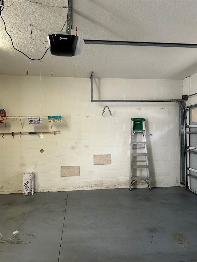 garage with concrete block wall and a garage door opener