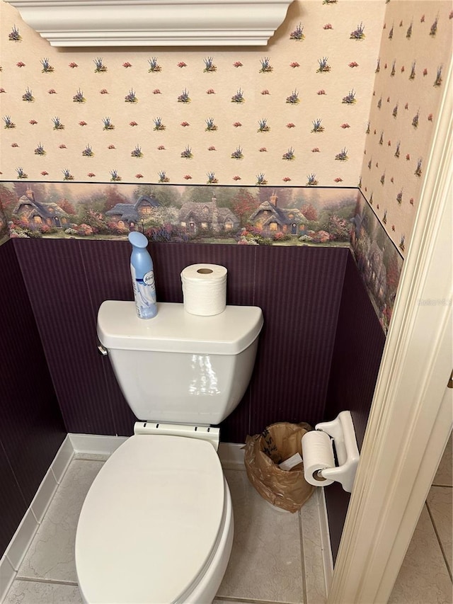 bathroom with wallpapered walls, toilet, and baseboards