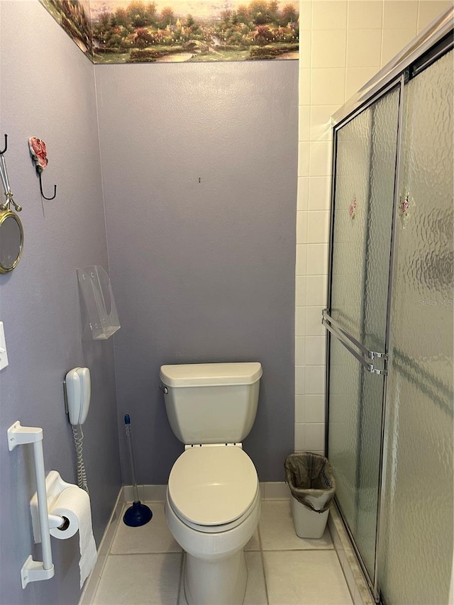 bathroom featuring tile patterned floors, a stall shower, and toilet