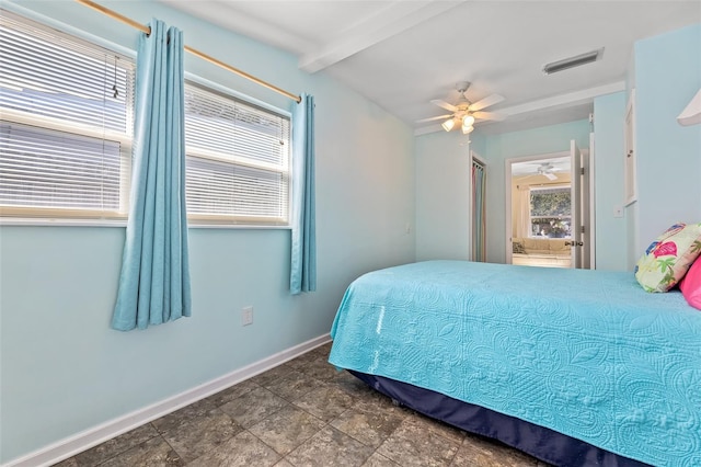 bedroom with ceiling fan and beam ceiling