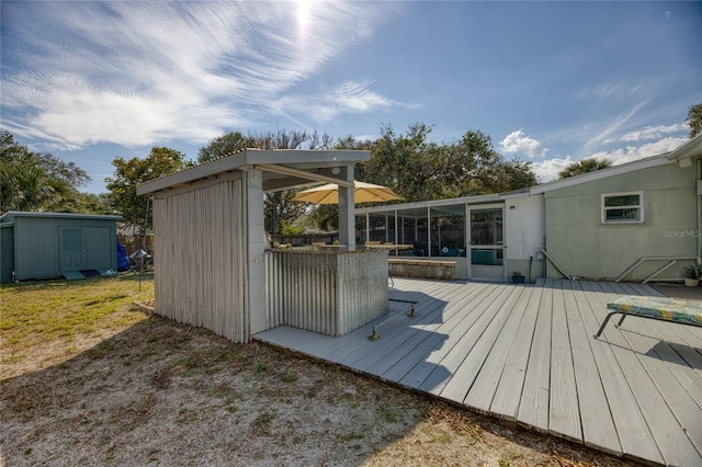 deck with a storage unit and a sunroom