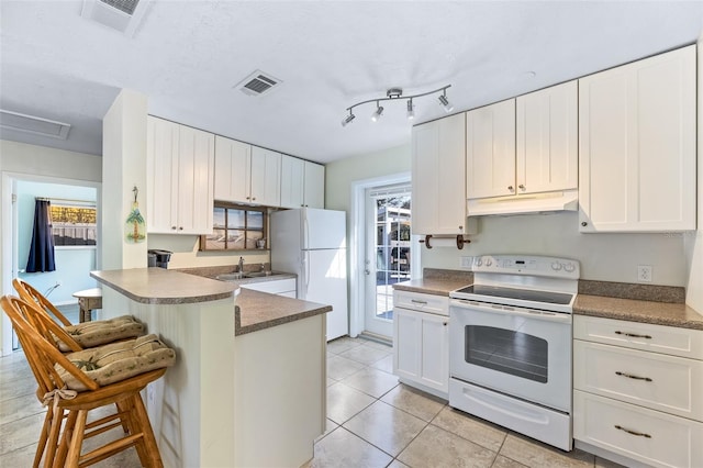 kitchen featuring sink, a breakfast bar area, white cabinets, kitchen peninsula, and white appliances