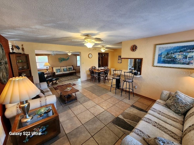 tiled living room with ceiling fan and a textured ceiling